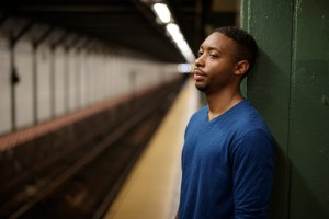 Young man in city at subway platform tired